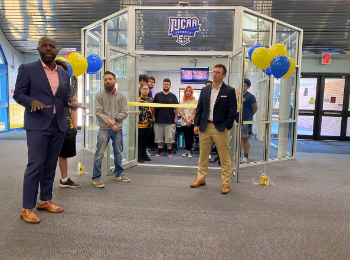Esports Arena Ribbon Cutting with a crowd of a dozen or so students, faculty, and staff present