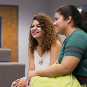 Two girls smile at group discussion in honors lounge